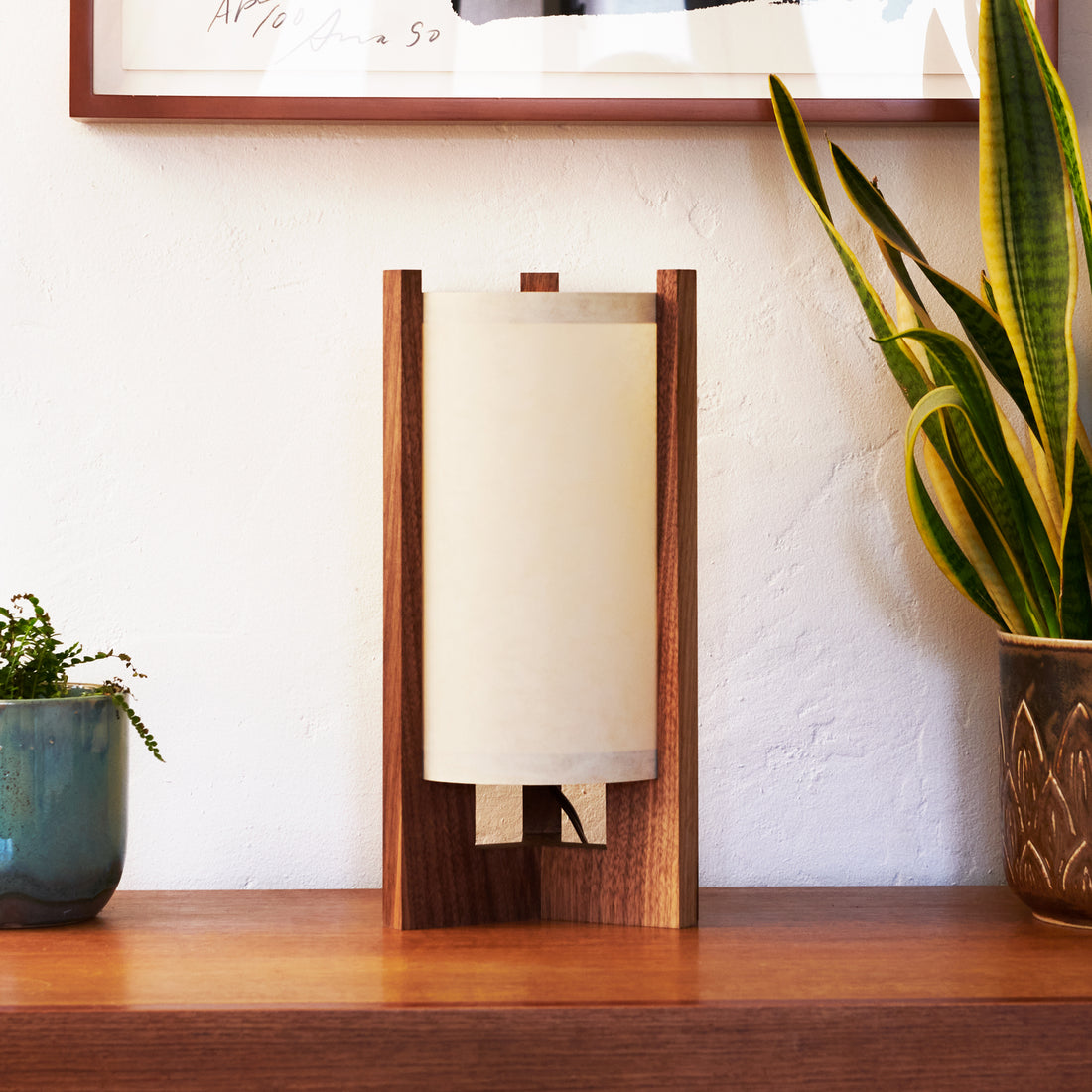 Walnut Table Lamp with White Lampshade on dresser next to plants and art