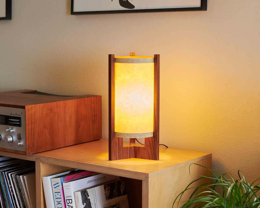 Japanese Mid Century Walnut Table Lamp next to a stereo